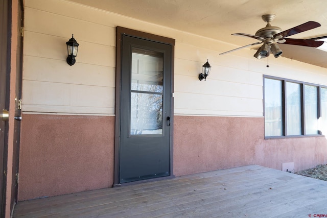 doorway to property featuring a wooden deck and ceiling fan