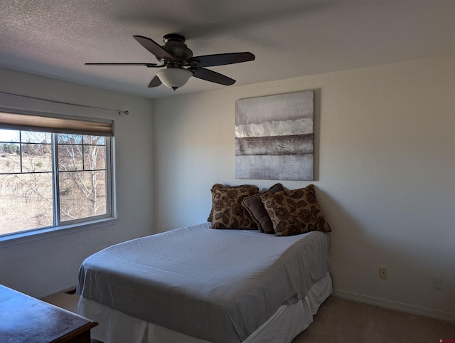 bedroom with ceiling fan and a textured ceiling