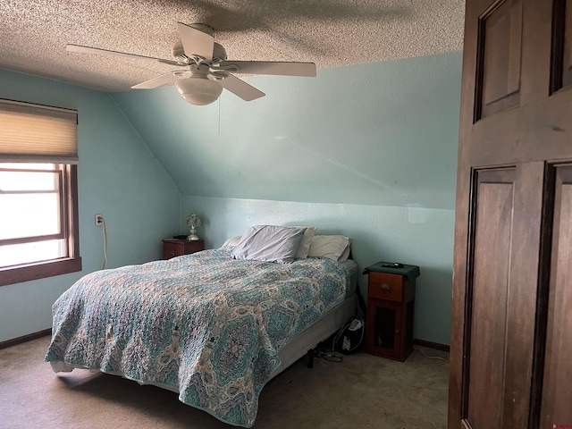 carpeted bedroom with ceiling fan, vaulted ceiling, and a textured ceiling