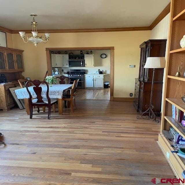 dining space with an inviting chandelier, crown molding, and light hardwood / wood-style floors