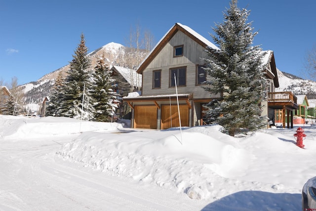 view of front of house with a garage and a deck with mountain view