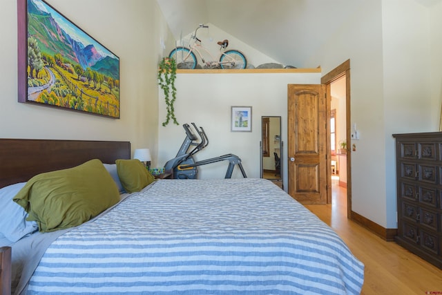 bedroom with vaulted ceiling and light hardwood / wood-style flooring