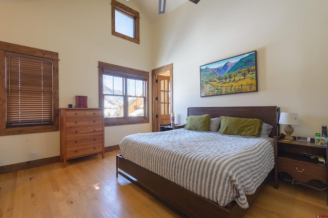 bedroom with light hardwood / wood-style floors and a high ceiling