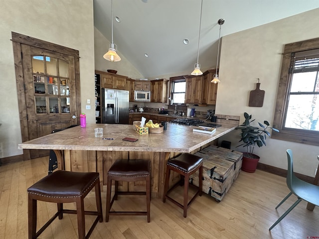 kitchen featuring hanging light fixtures, a breakfast bar area, stainless steel appliances, and kitchen peninsula