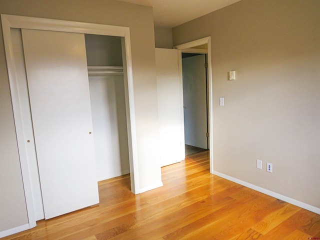 unfurnished bedroom with a closet and light hardwood / wood-style flooring