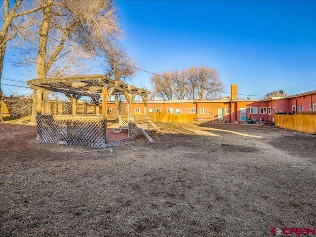 view of play area featuring fence and a pergola