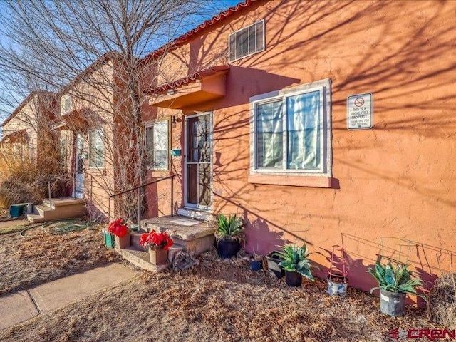 doorway to property with visible vents and stucco siding