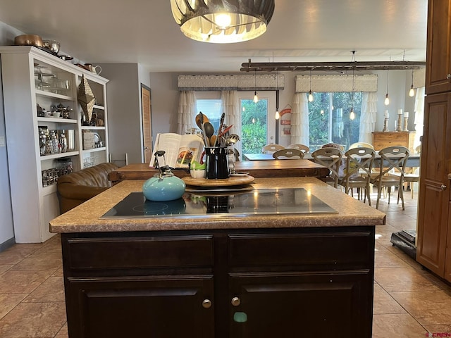 kitchen featuring dark brown cabinets, a center island, pendant lighting, and black electric cooktop