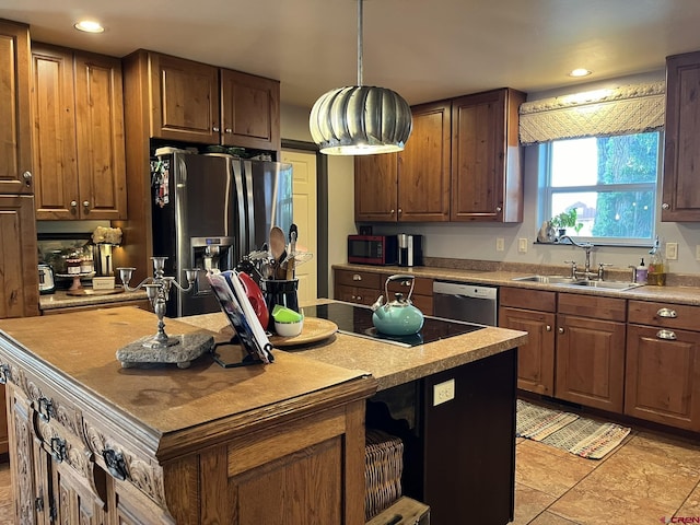 kitchen featuring appliances with stainless steel finishes, decorative light fixtures, sink, and a kitchen island