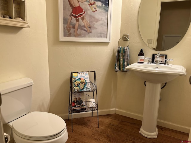 bathroom featuring hardwood / wood-style flooring and toilet