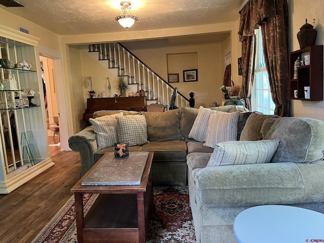 living room with a textured ceiling and dark hardwood / wood-style flooring