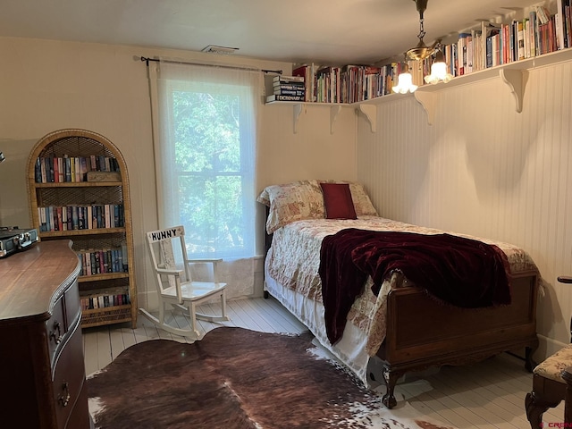 bedroom with multiple windows, light hardwood / wood-style flooring, and a chandelier