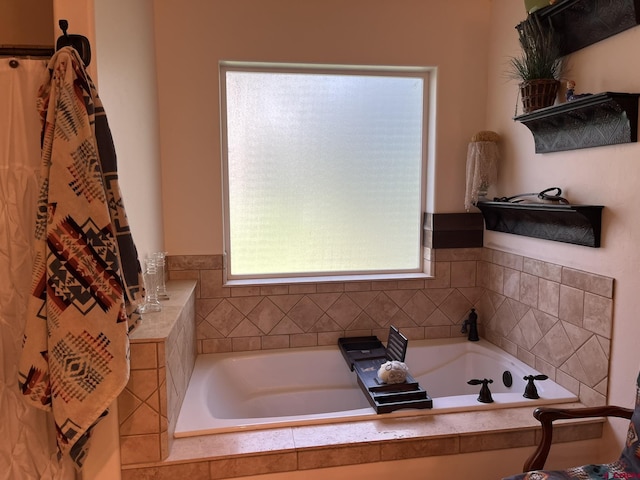 bathroom featuring plenty of natural light and tiled bath