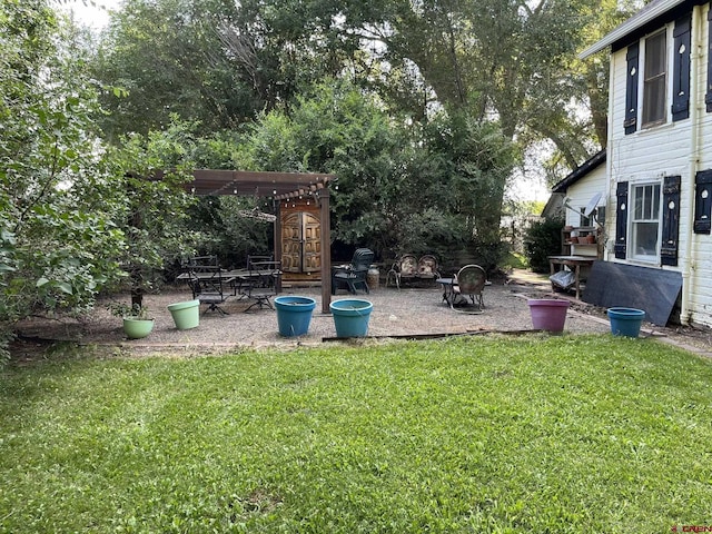 view of yard featuring a pergola and a fire pit