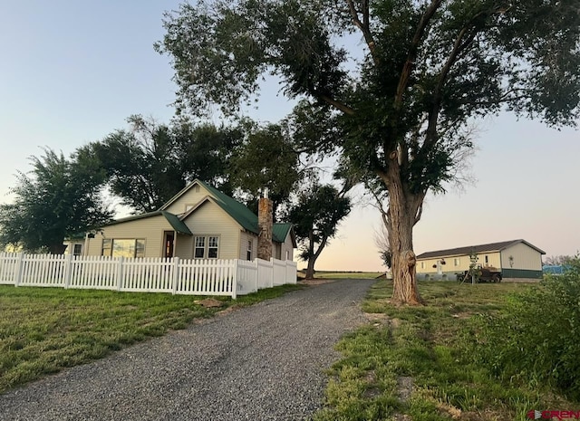 property exterior at dusk with a lawn