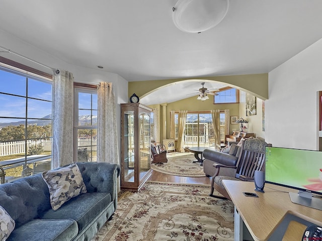 living room featuring vaulted ceiling, ceiling fan, and light wood-type flooring