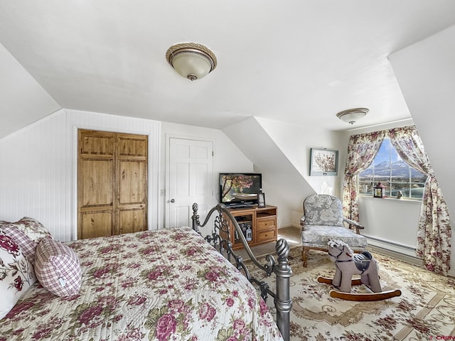 bedroom featuring a baseboard heating unit and vaulted ceiling