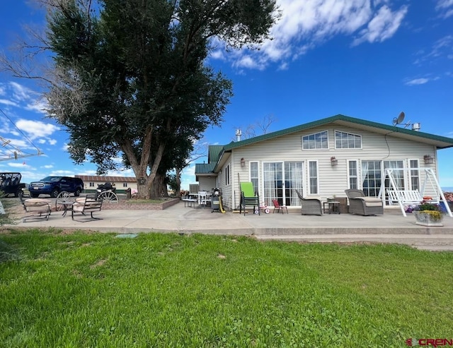 rear view of property featuring a patio area and a lawn