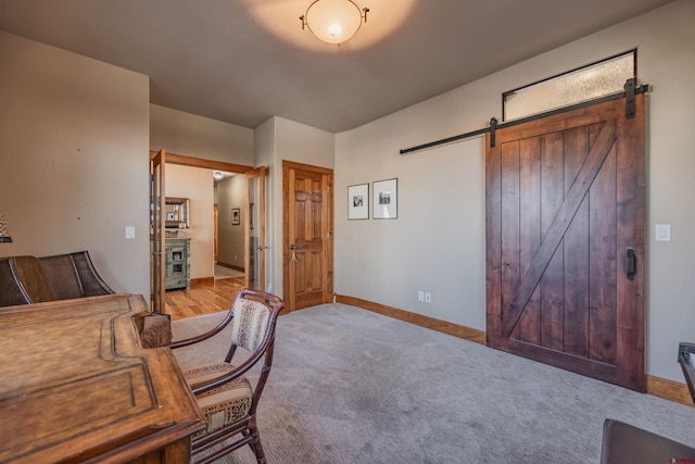 carpeted home office with a barn door