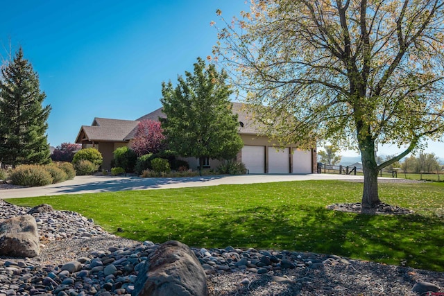 view of front of property with a garage and a front lawn