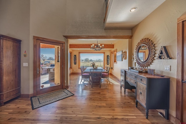 foyer with an inviting chandelier and wood-type flooring