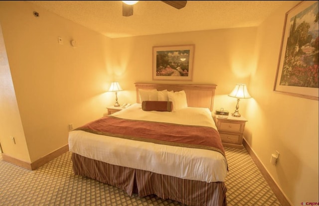 carpeted bedroom with ceiling fan and a textured ceiling