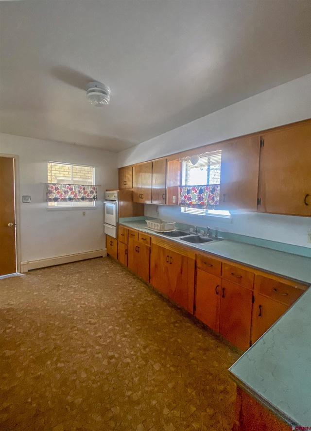 kitchen featuring a baseboard radiator, sink, and white oven