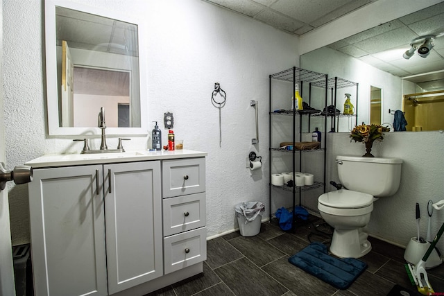 bathroom with vanity, a paneled ceiling, and toilet