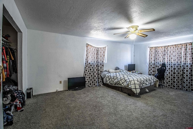 bedroom with a textured ceiling, carpet floors, and ceiling fan