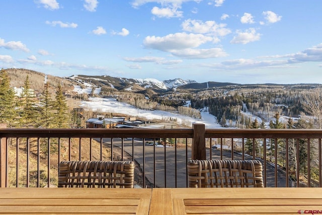 snow covered deck with a mountain view