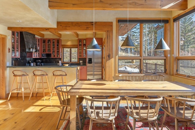 dining space featuring wet bar and light wood-style floors