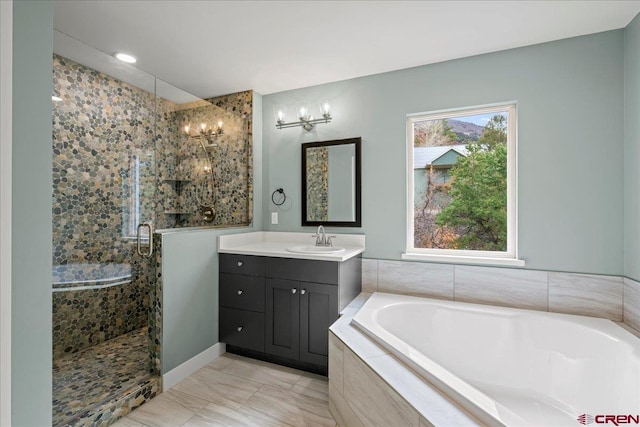 bathroom featuring independent shower and bath, vanity, and an inviting chandelier
