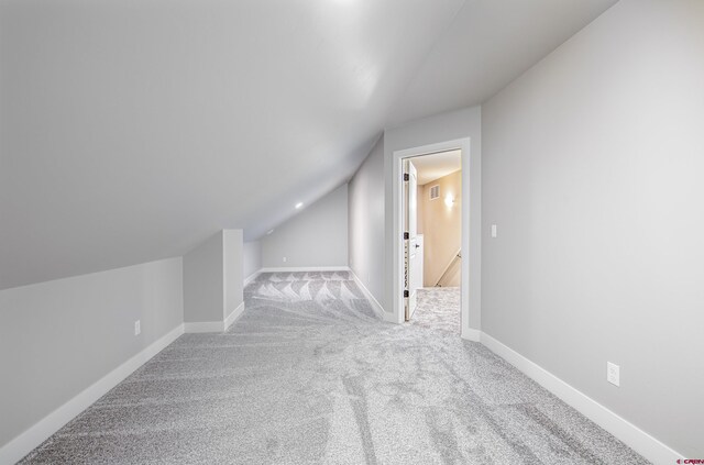 additional living space with light carpet and lofted ceiling