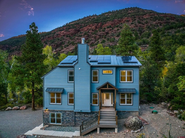 back house at dusk featuring solar panels