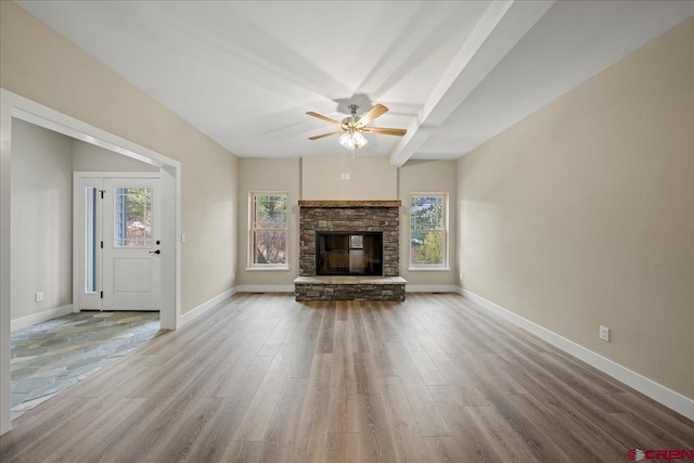 unfurnished living room featuring a stone fireplace, ceiling fan, and light hardwood / wood-style flooring