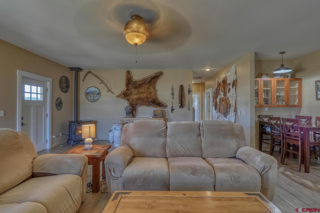 living room featuring light hardwood / wood-style flooring and a wood stove