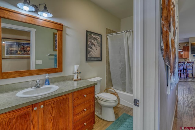 full bathroom featuring vanity, hardwood / wood-style floors, toilet, and shower / bath combo with shower curtain