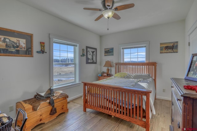 bedroom with light hardwood / wood-style floors and ceiling fan