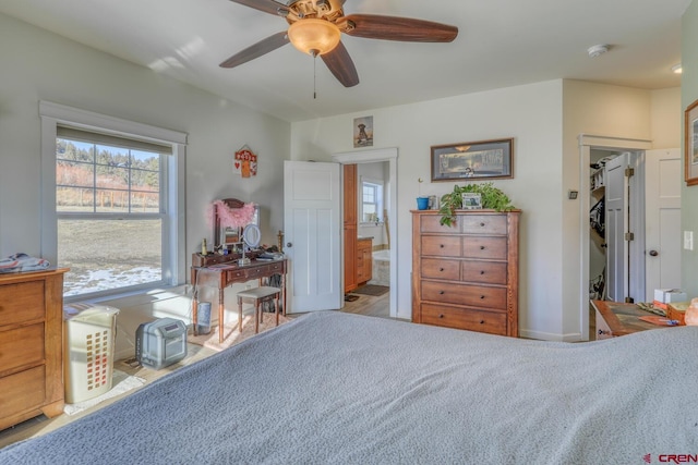 bedroom with ensuite bathroom, light carpet, and ceiling fan