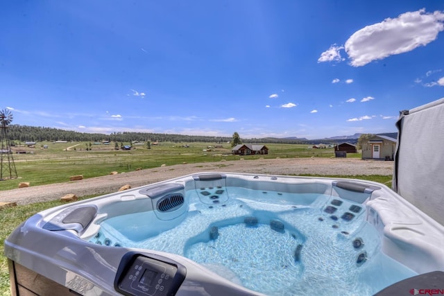 view of pool featuring a hot tub and a rural view