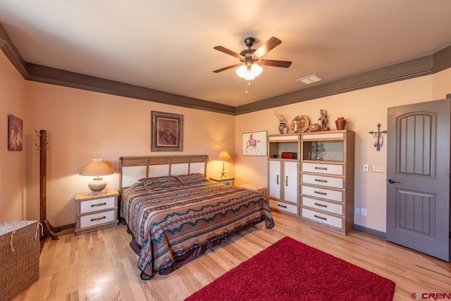 bedroom featuring crown molding, ceiling fan, and light hardwood / wood-style flooring