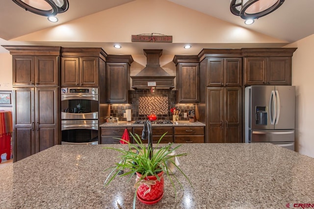 kitchen featuring premium range hood, lofted ceiling, and stainless steel appliances