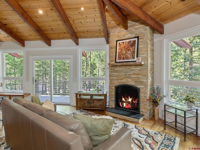 living room with a stone fireplace, light hardwood / wood-style floors, lofted ceiling with beams, and wooden ceiling