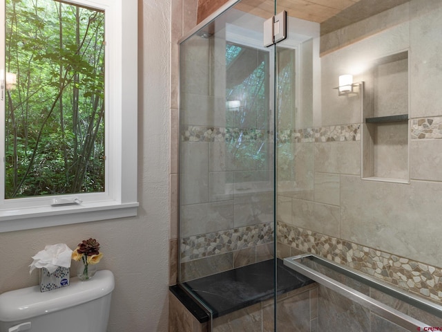 bathroom with toilet and tiled shower