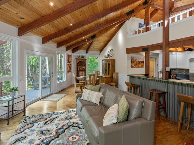 living room with wood ceiling, beam ceiling, high vaulted ceiling, and light wood-type flooring