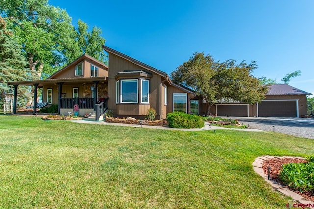 view of front of property featuring a porch, a garage, and a front lawn