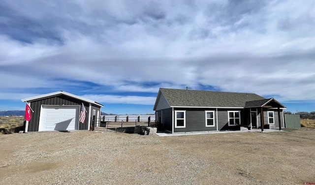 view of front facade with a garage and an outbuilding