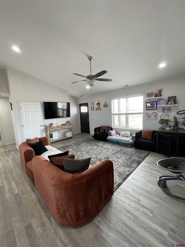 living room featuring ceiling fan, lofted ceiling, and light hardwood / wood-style floors