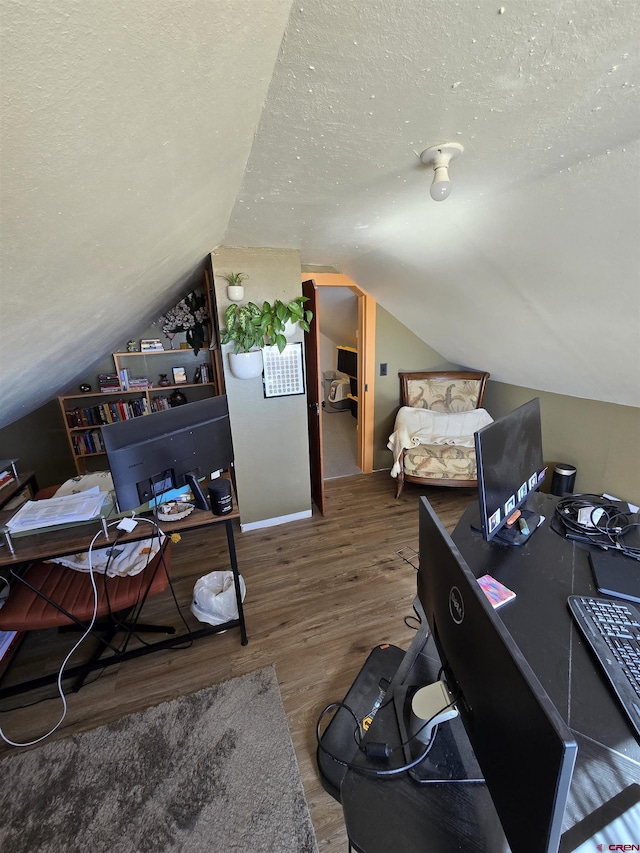 office area featuring lofted ceiling, hardwood / wood-style floors, and a textured ceiling