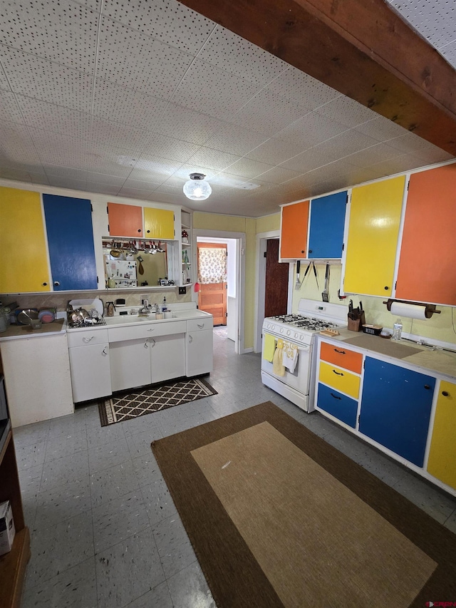 kitchen featuring white cabinetry and gas range gas stove